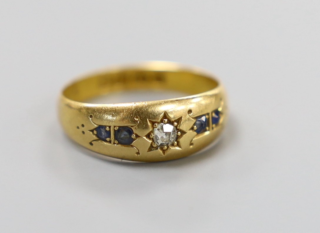 A late Victorian 18ct gold, single stone diamond and four stone sapphire gypsy set ring, size N, gross weight 3.2 grams.